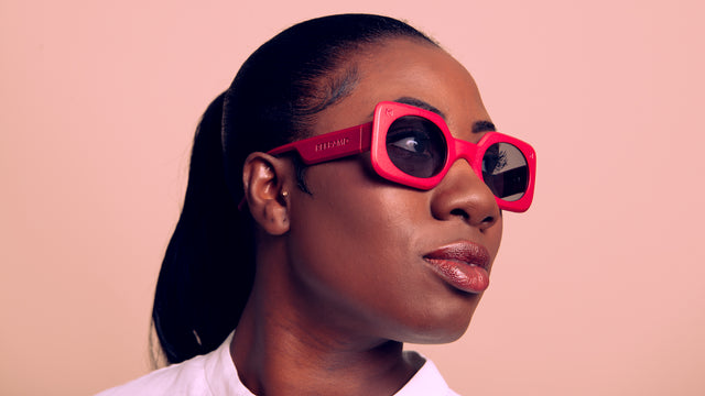 Stylish person wearing pink-framed oversized sunglasses with reflective lenses