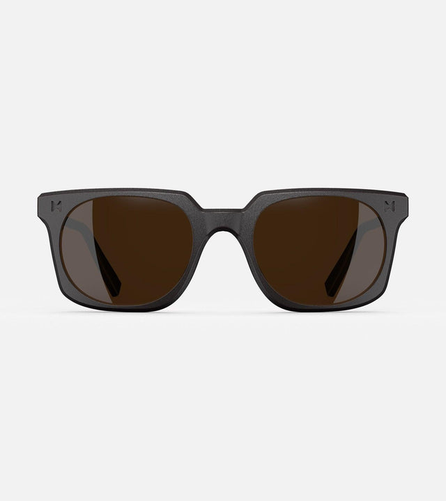 Black square-frame glasses with dark lenses, designed with an inclusive fit for all nose bridges, featuring a modern minimalist design.