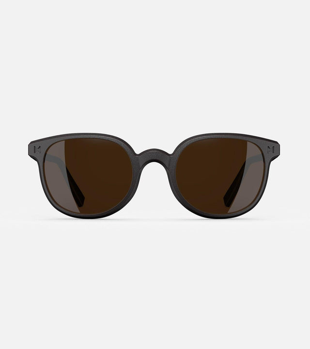 Modern black framed sunglasses for narrow nose bridges with round brown lenses on a white background